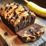 - 3 ripe bananas, thoroughly mashed - 1/2 cup creamy peanut butter - 1/2 cup granulated sugar - 1/4 cup packed brown sugar - 1/4 cup unsweetened applesauce - 2 large eggs - 1 teaspoon pure vanilla extract - 1 1/2 cups all-purpose flour - 1/2 teaspoon baking soda - 1/2 teaspoon baking powder - 1/4 teaspoon salt - 1/2 cup chocolate chips (dark or semi-sweet) - 1/4 cup chopped walnuts (optional) The key to this banana bread is the balance of flavors. The ripe bananas add natural sweetness and moisture. I always choose bananas that are very ripe for the best taste. Creamy peanut butter gives it a rich flavor and creamy texture. Next, we have sugars. Granulated sugar adds sweetness, while brown sugar brings a hint of molasses. Applesauce replaces some fat and keeps the bread moist. Adding eggs gives structure. Pure vanilla extract enhances the overall flavor. For the dry part, all-purpose flour is the base. Baking soda and baking powder help it rise. A little salt rounds out the flavors. Finally, chocolate chips add a delightful richness, while walnuts, if you choose to add them, give an awesome crunch. Each ingredient plays an important role in making this a delightful treat. First, preheat your oven to 350°F (175°C). This step is key for even baking. While the oven heats, prepare your loaf pan. You can grease it lightly with cooking spray or butter. Alternatively, you might line it with parchment paper. This makes it easy to remove the bread later. Next, take three ripe bananas and mash them well in a large bowl. Then, add in 1/2 cup of creamy peanut butter. Mix these until smooth. Now, it's time to add the sugars. Include 1/2 cup of granulated sugar and 1/4 cup of brown sugar. Add 1/4 cup of unsweetened applesauce and two large eggs. Finish with 1 teaspoon of pure vanilla extract. Whisk everything until it’s creamy and well combined. In another bowl, whisk together the dry ingredients. Use 1 1/2 cups of all-purpose flour, 1/2 teaspoon of baking soda, 1/2 teaspoon of baking powder, and 1/4 teaspoon of salt. Mixing these first ensures they blend well into the batter. Now, take the dry mix and add it to the wet mix. Use a spatula to fold the two together gently. Be careful not to over-mix; it's okay if a few lumps remain. After that, fold in 1/2 cup of chocolate chips and, if you like, 1/4 cup of chopped walnuts for some crunch. Once your batter is ready, transfer it to the prepared loaf pan. Smooth the top with your spatula. Place the pan in the preheated oven. Bake for 60-65 minutes. You know it's done when a toothpick comes out clean or with a few moist crumbs. After baking, let the banana bread cool in the pan for about 10 minutes. Then, carefully move it to a wire rack to cool completely. To serve, slice the bread and arrange it on a plate. Drizzle some extra peanut butter on top and scatter a few chocolate chips for flair. You can even place a fresh banana beside the slices for a lovely touch. You can switch out some ingredients for healthier options. Instead of peanut butter, try almond butter. It adds a nice touch. For sugar, use coconut sugar. It gives a deeper flavor with a lower glycemic index. If you need to make this vegan, replace the eggs with applesauce. Use 1/4 cup of applesauce for each egg. This keeps the bread moist and tasty. Getting the texture just right is key. You want your bread moist but not soggy. If the batter seems too thick, add a splash of milk to loosen it. To check if your bread is done, insert a toothpick in the center. If it comes out clean or with a few crumbs, it’s ready. If there’s wet batter, bake it a bit longer. To serve this bread beautifully, slice it evenly. Use a sharp knife for clean cuts. Place the slices on a rustic wooden board. Drizzle some creamy peanut butter on top. Scatter a few chocolate chips for extra appeal. For a lovely touch, add a fresh banana beside the slices. This makes the dish look inviting and adds some color. {{image_4}} You can easily change the flavor of your chocolate peanut butter banana bread. Adding spices like cinnamon or nutmeg brings warmth and depth. Just a pinch can change the taste. You might also try adding mix-ins like dried fruit or seeds. Chopped dates or cranberries add sweetness. Pumpkin seeds or sunflower seeds offer a nice crunch. If you need a gluten-free option, use alternative flours. Almond flour or oat flour work great. They keep the bread moist and tasty. For a low-sugar version, you can use less sugar or a sugar substitute. Applesauce already adds sweetness, so you can cut back on granulated sugar. Seasonal fruits can enhance your banana bread. Try adding fresh berries in the summer or chopped apples in the fall. Nuts, like pecans or hazelnuts, can add a seasonal twist too. For festive occasions, think about adding spices like ginger or cloves. They give a holiday vibe to every slice. To store banana bread at room temperature, wrap it in plastic wrap. This keeps it fresh. Place it in a cool and dry spot, away from sunlight. It can last for 2 to 3 days. Enjoy the soft texture and rich flavors during this time. Refrigerating banana bread helps it stay fresh longer. It can last for about a week in the fridge. Just place it in an airtight container. This method slows down spoilage and helps keep the bread moist. However, it may lose some freshness in flavor. Freezing banana bread is a great way to save it for later. First, wrap it tightly in plastic wrap, then place it in a freezer bag. This protects it from freezer burn. It can last for up to 3 months in the freezer. When ready to eat, let it thaw in the fridge overnight. For the best texture, warm it up in the oven for a few minutes before serving. Yes, you can use frozen bananas. They are perfect for banana bread. Frozen bananas are often riper and sweeter. To use them, thaw the bananas first. Drain any extra liquid. Then mash them well before mixing. This helps keep your bread moist and flavorful. To reduce the sweetness, cut back on sugar. You can use half the granulated sugar. You can also skip the brown sugar. Add more mashed bananas for flavor. You might try unsweetened applesauce too. This will keep the bread moist without adding extra sugar. If your banana bread is too dense, check your mixing method. Over-mixing can cause density. Mix wet and dry ingredients just until combined. If your bananas are too large, use smaller ones. You can also add a bit more baking powder. This helps to lighten the texture. Chocolate peanut butter banana bread lasts a few days at room temperature. Store it in a sealed container. If you refrigerate it, it can last up to a week. For longer storage, freeze it for up to three months. Just slice and wrap each piece tightly. Yes, you can add protein powder. Use a small amount, about 1/4 cup. Choose a protein that blends well. Mix it with the dry ingredients before combining. This way, it won’t change the bread’s texture too much. Adjust the liquid slightly if needed to keep it moist. This article covered all you need to know about making Chocolate Peanut Butter Banana Bread. You learned the key ingredients, step-by-step instructions, and useful baking tips. Remember, you can customize the recipe to suit your diet and taste. Store it well to enjoy later! Experiment with flavors and have fun baking. Your kitchen will fill with delicious scents and smiles. Happy baking!